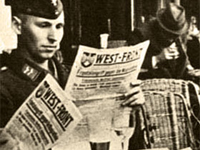 soldat allemand lisant son journal à une terrasse de café durant l'Occupation